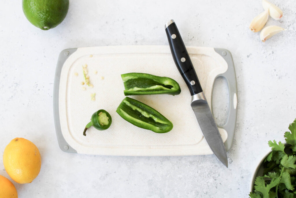 Sliced jalapeno on a cutting board with a knife
