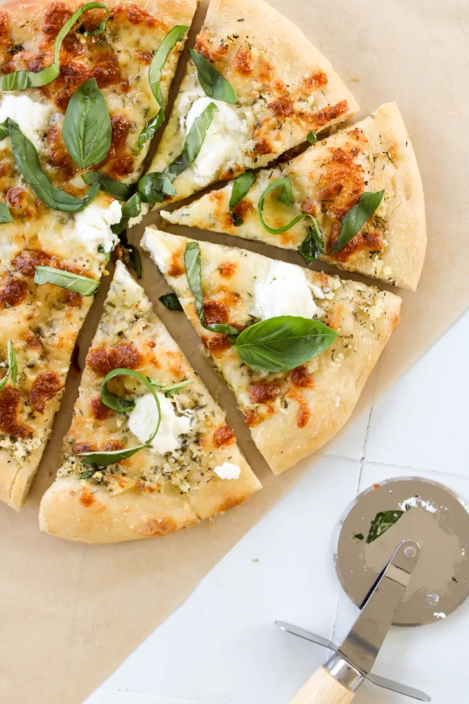 olive oil pizza slices with fresh basil and three cheeses. 
