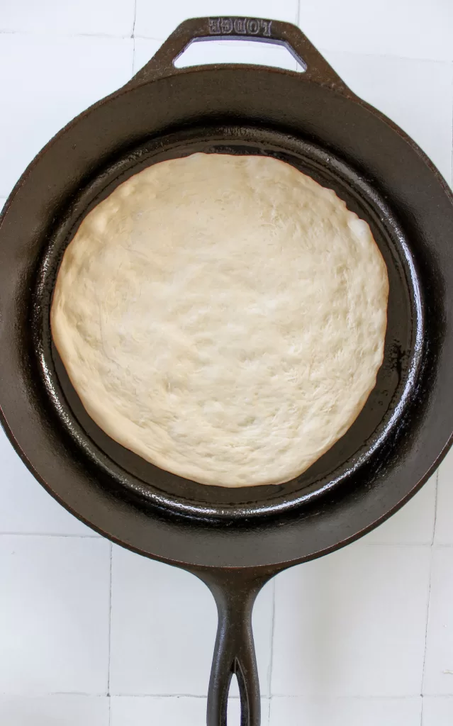 Pizza dough in a cast iron skillet 
