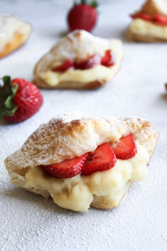 Strawberry Croissant filled with vanilla custard and strawberries, dusted with powdered sugar. 