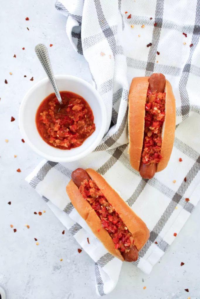 Jersey Mikes style cherry pepper relish in a bowl and on top of hot dogs. 