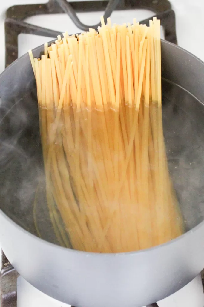 linguini noodles in a boiling pot of water 